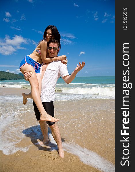 Young couple enjoying themselves on a beautiful day at the beach. Young couple enjoying themselves on a beautiful day at the beach