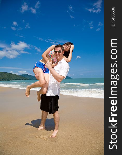 Young multiethnic couple enjoying themselves on a beautiful day at the beach. Young multiethnic couple enjoying themselves on a beautiful day at the beach