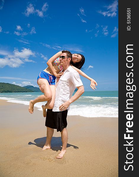 Young multiethnic couple enjoying themselves on a beautiful day at the beach. Young multiethnic couple enjoying themselves on a beautiful day at the beach