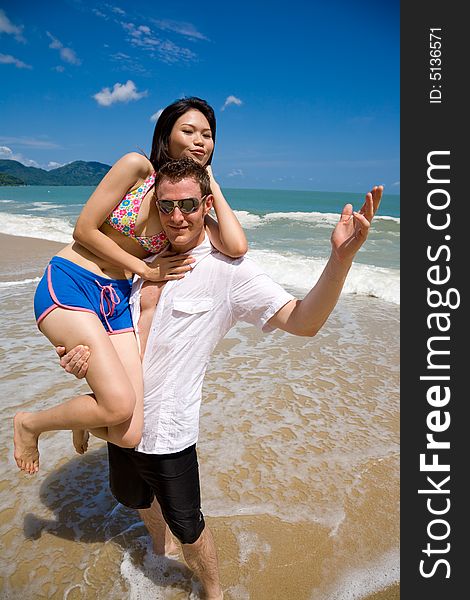 Young multiethnic couple enjoying themselves on a beautiful day at the beach. Young multiethnic couple enjoying themselves on a beautiful day at the beach