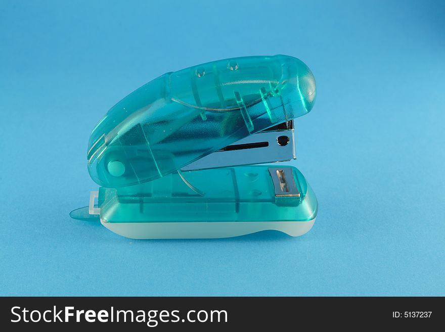 Office stapler on the blue background