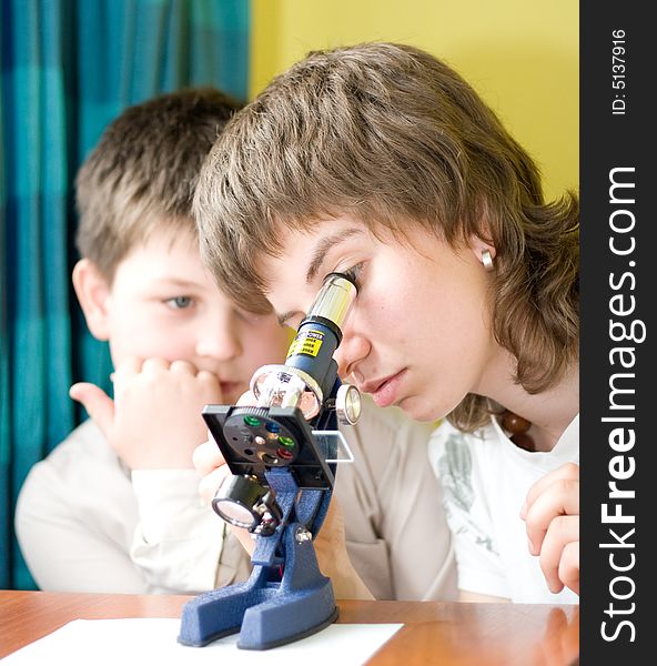 Boy and girl with a microscope in a laboratory