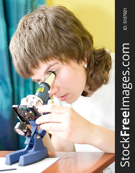 Girl with a microscope in a laboratory