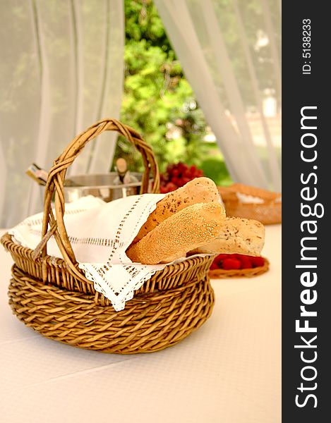 Table setting with bread basket outdoors with wine bottles on background. Table setting with bread basket outdoors with wine bottles on background