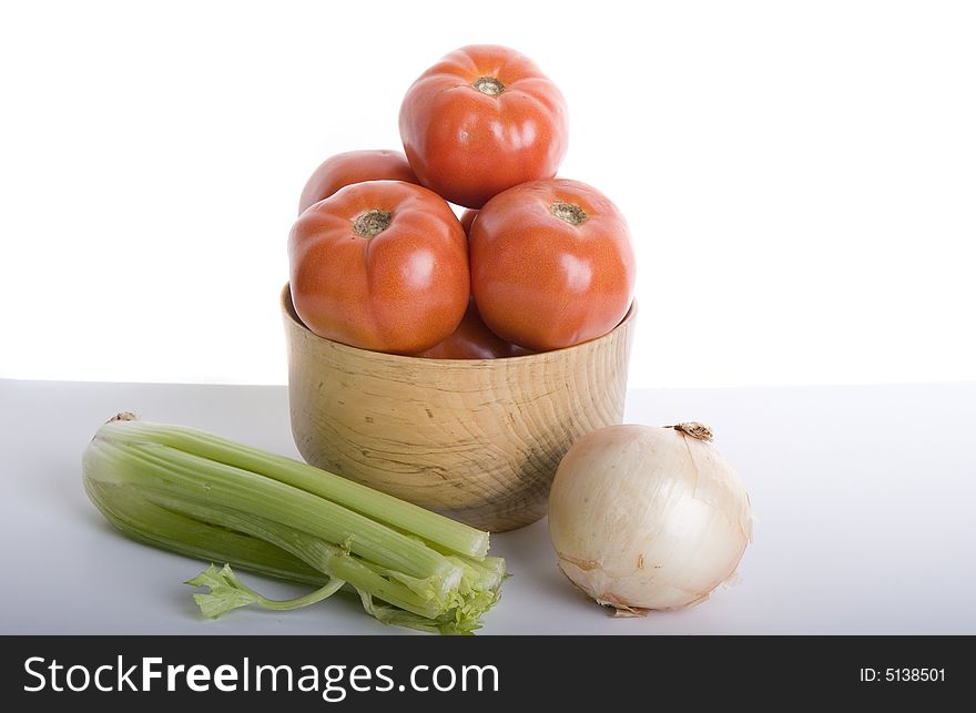 Fresh tomatoes in a wood bowl with an onion and celery. Fresh tomatoes in a wood bowl with an onion and celery