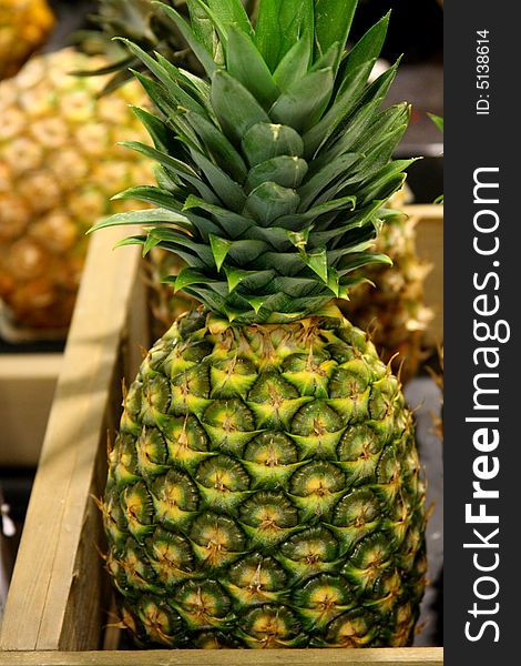 Fresh pineapples in a crate at a grocery store