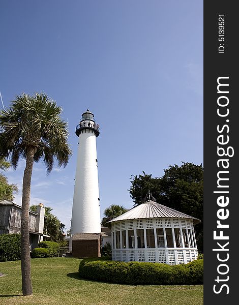 A lighthouse, palm tree, and gazebo on the coast. A lighthouse, palm tree, and gazebo on the coast