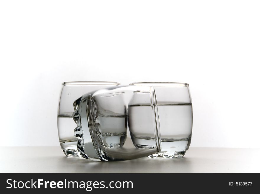 Three small glasses of vodka on a white background