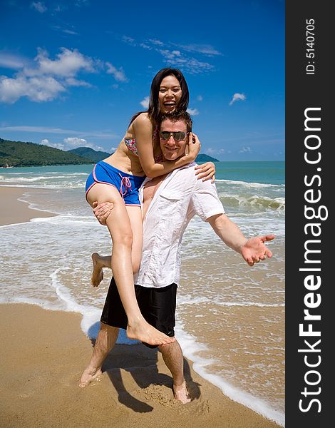 Young multiethnic couple enjoying themselves on a beautiful day at the beach. Young multiethnic couple enjoying themselves on a beautiful day at the beach