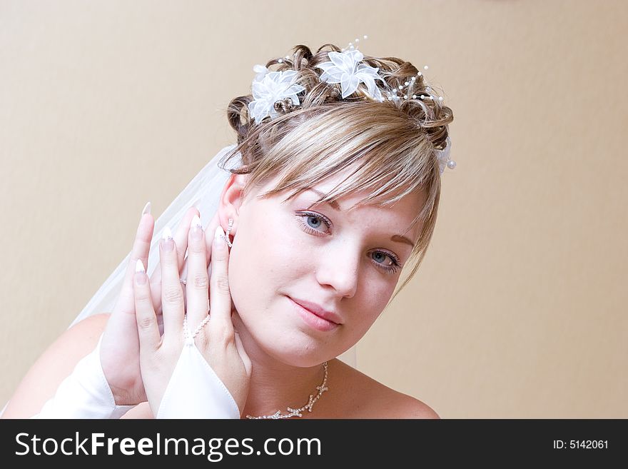 A beautiful bride carefully putting on ear-ring. A beautiful bride carefully putting on ear-ring
