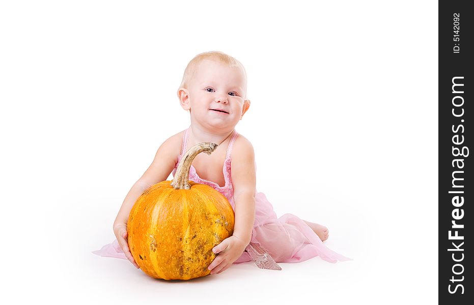 Smiling little girl embraces pumpkin and a crystal shoe near by. Smiling little girl embraces pumpkin and a crystal shoe near by