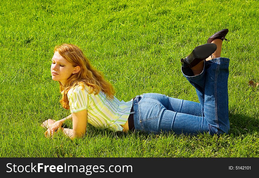 Beauty girl is smiling and relaxing on the grass. Beauty girl is smiling and relaxing on the grass