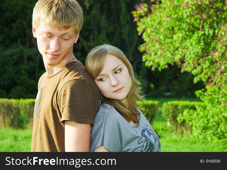 Peaceful couple of young adults outdoors, man attentively shut off his girlfriend from the sun