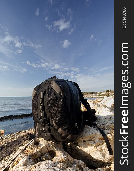 Photographic backpack on rock at sea coast