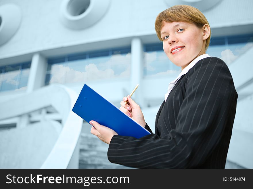 Business woman with folder stand on front building
