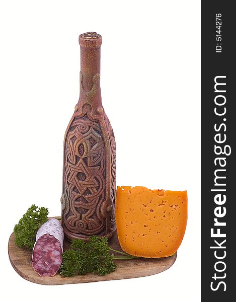 Still-life on a wooden hardboard with parsley, sausage, cheese and bottle isolated on white.