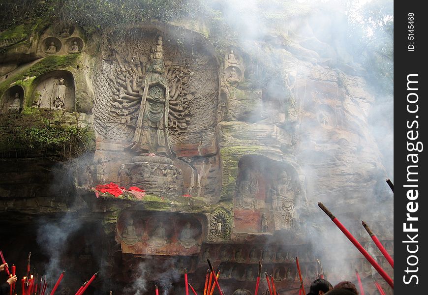 Ancient statue of the gan-yin (Avalokite svara) with thousands of hands in Sichuan province, China. It is goddess of mercy in Buddhism. Below is the burning joss sticks by buddhism believers. Ancient statue of the gan-yin (Avalokite svara) with thousands of hands in Sichuan province, China. It is goddess of mercy in Buddhism. Below is the burning joss sticks by buddhism believers.