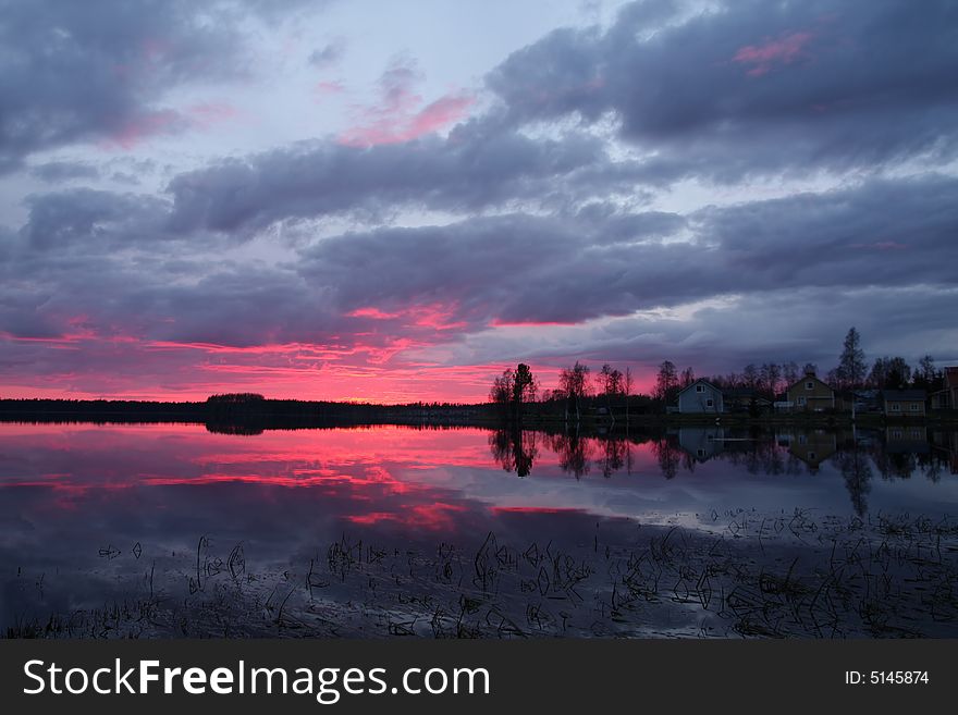 Beautiful sunset over lake, reflecting in the water