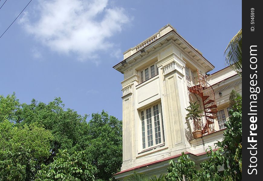 Yellow beautiful building with a stair in a side, in Havana Cuba