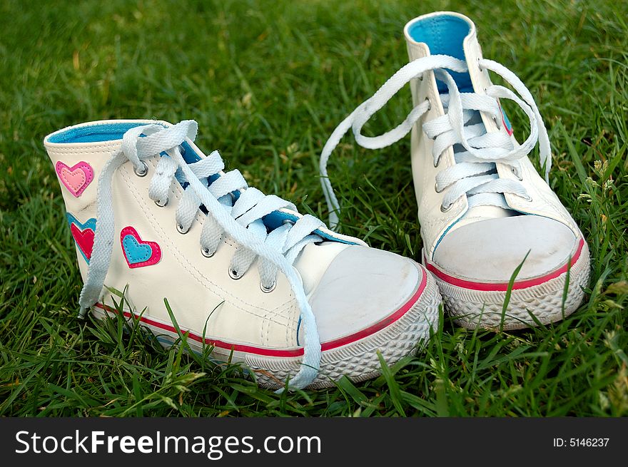 A pair of white shoes in the grass. A pair of white shoes in the grass