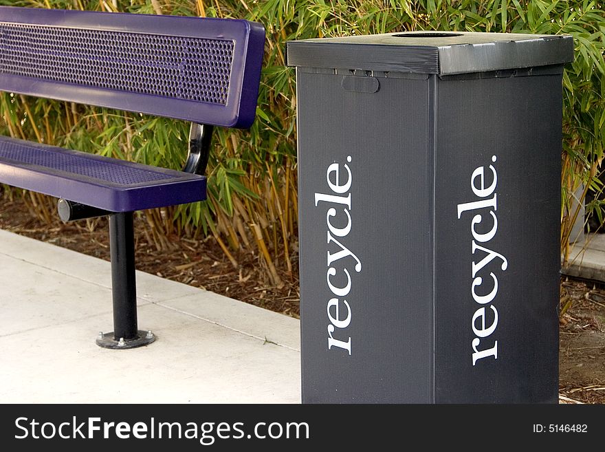 Purple park bench and a black cardboard recycle box. Purple park bench and a black cardboard recycle box.