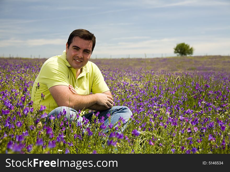 Young man sit in a flower field