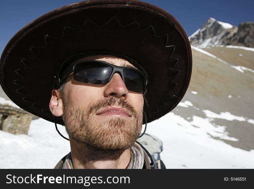 Man with large hat enjoying the sun in the mountains, annapurna, nepal