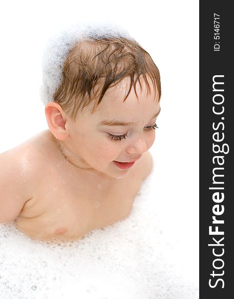 Delighted boy playing in shampoo foam. Delighted boy playing in shampoo foam