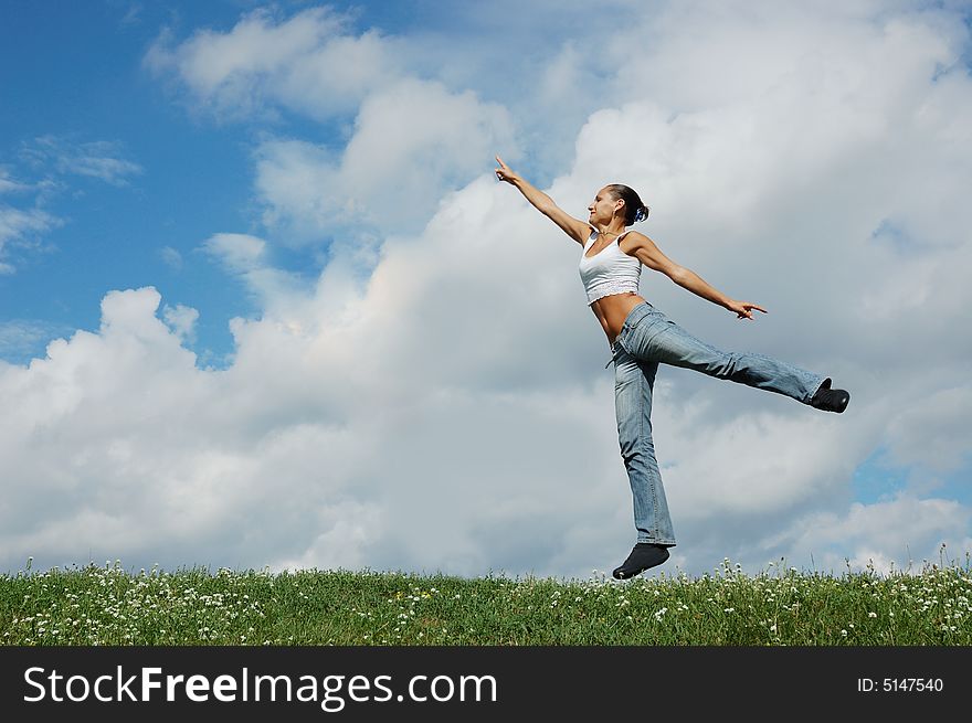 Jumping girl on the green meadow