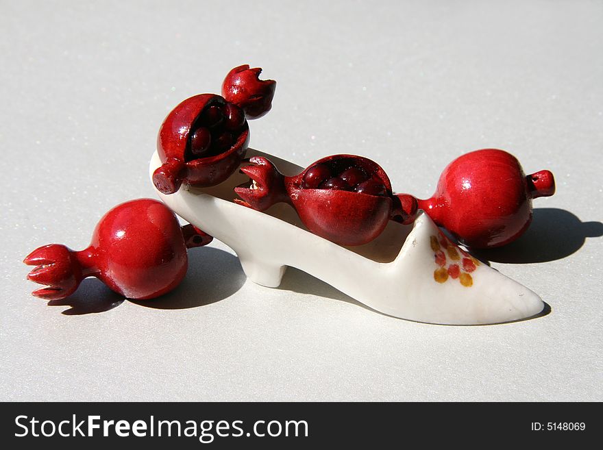 Red fruits of a pomegranate on a stone shoe. Red fruits of a pomegranate on a stone shoe