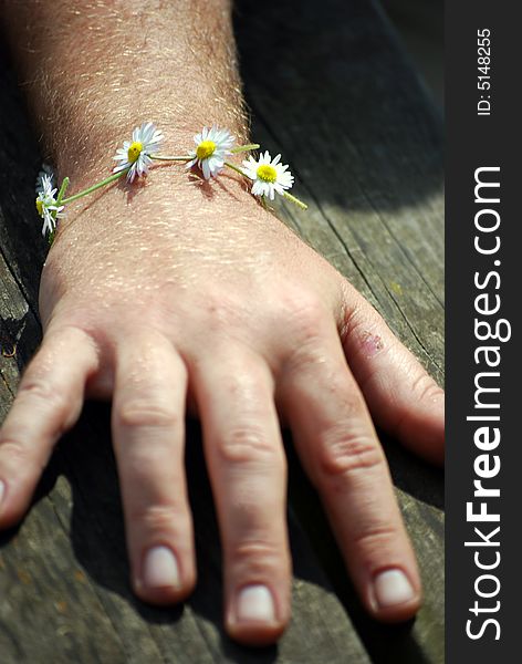 Shot of a man wearing a daisy chain bracelet. Shot of a man wearing a daisy chain bracelet