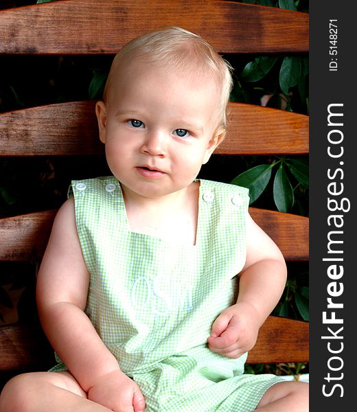 Baby boy on rocking chair on front porch of family home. Baby boy on rocking chair on front porch of family home