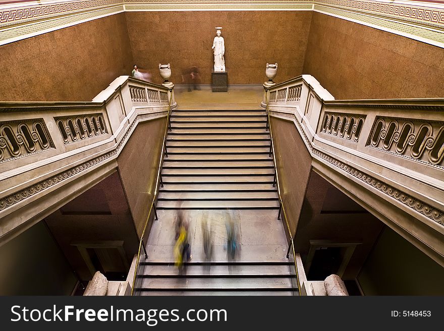 Blurred people on museum staircase.