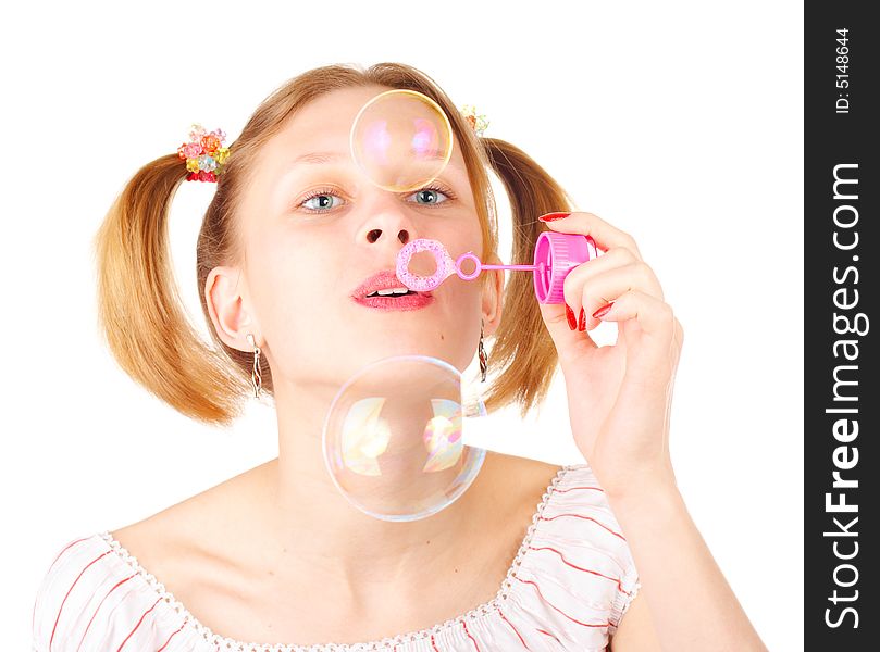 Pretty young girl with soap bubbles over white