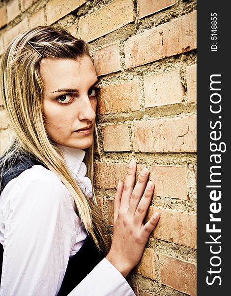 Young blond woman on brickwall. Young blond woman on brickwall