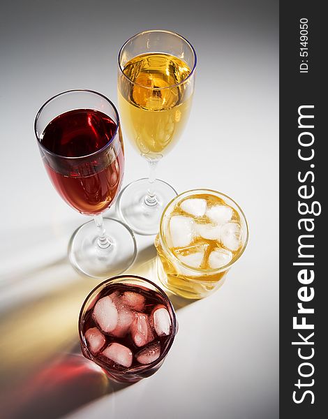 Beautiful glasses with wine and a cocktail on a white background