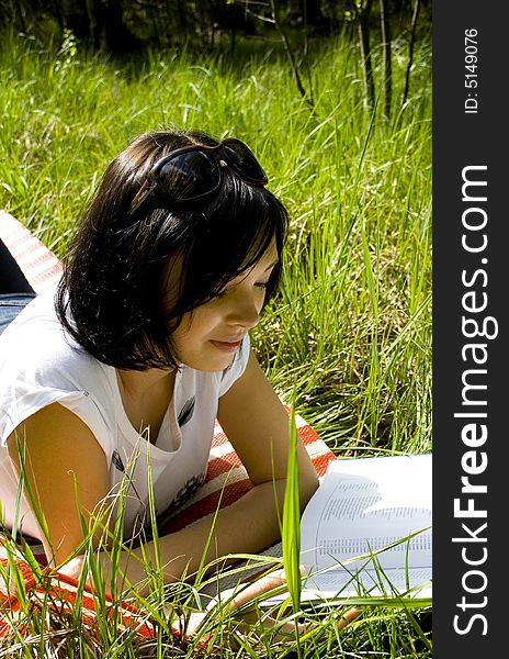 Pretty Young Brunette Readind In The Park