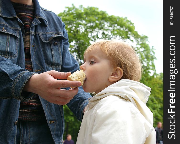 Daddy gives to daughter ice-cream near a fountain. Daddy gives to daughter ice-cream near a fountain