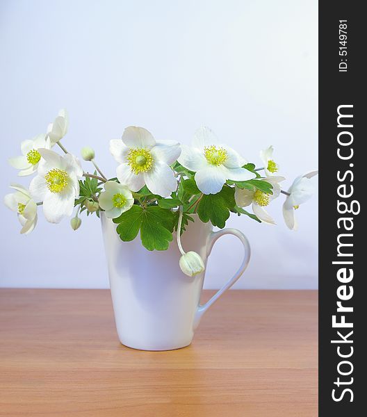 Bouquet of spring flowers in a white cup