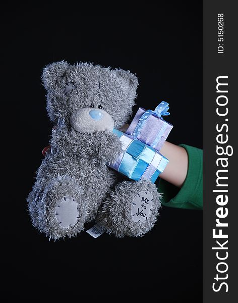 Teddy bear in hand at black background
