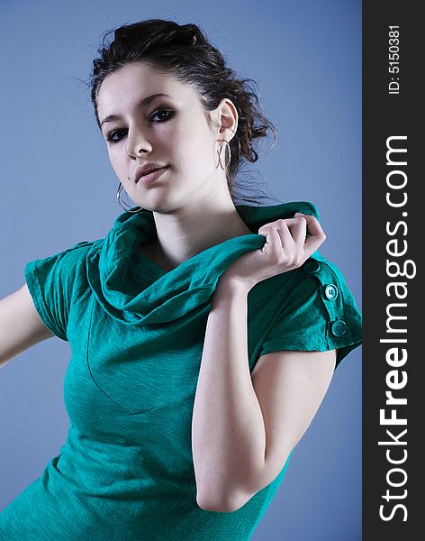 Beauty fashion woman in green clothes at blue background. Beauty fashion woman in green clothes at blue background