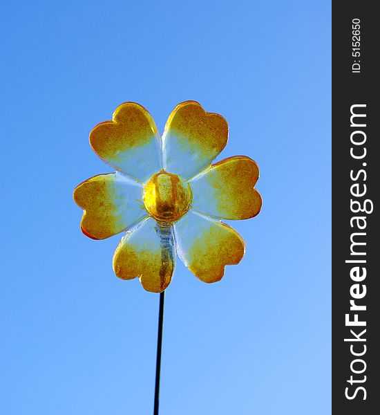 Plastic flower in front of blue sky