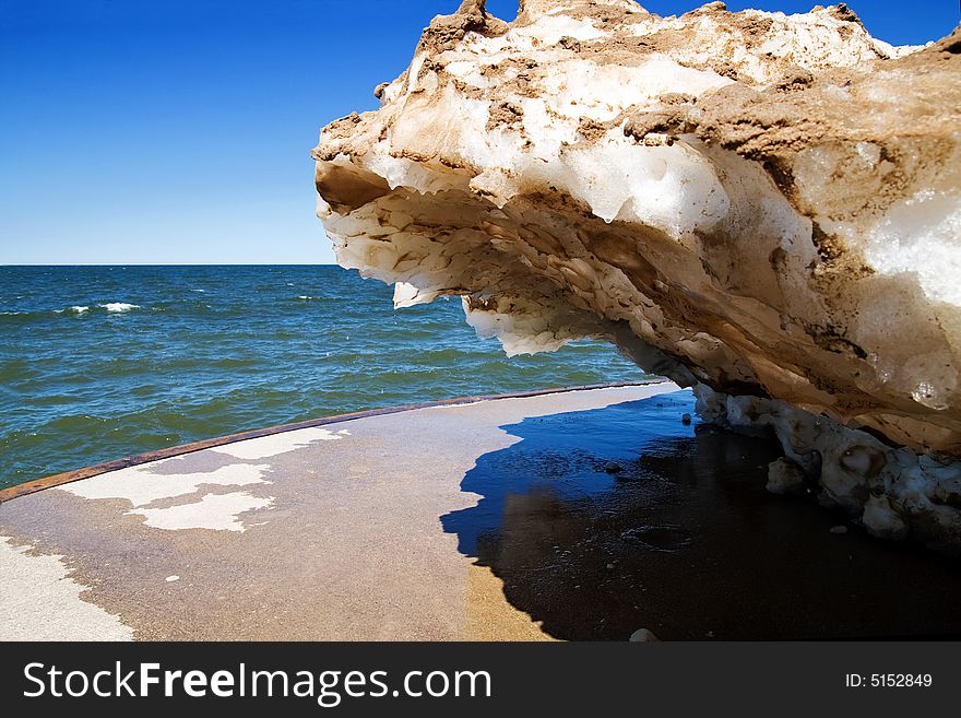 A snow drift, embedded with sand from the harsh winter winds, melts on a warm spring day at a Lake Michigan pier. A snow drift, embedded with sand from the harsh winter winds, melts on a warm spring day at a Lake Michigan pier