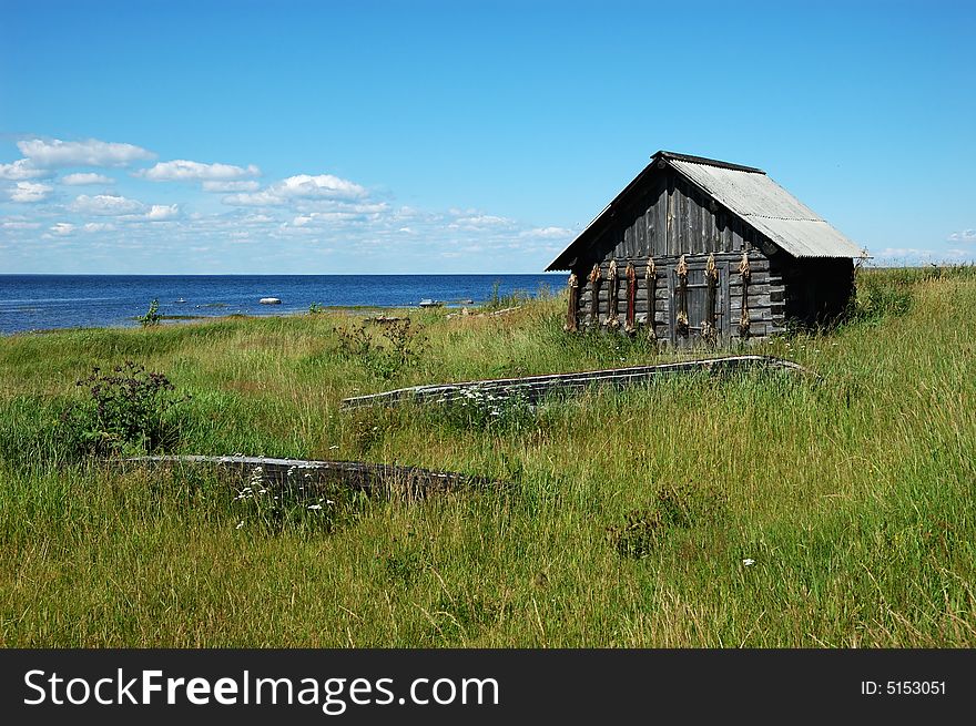 Wooden shed with fishing cordages on the lake bank