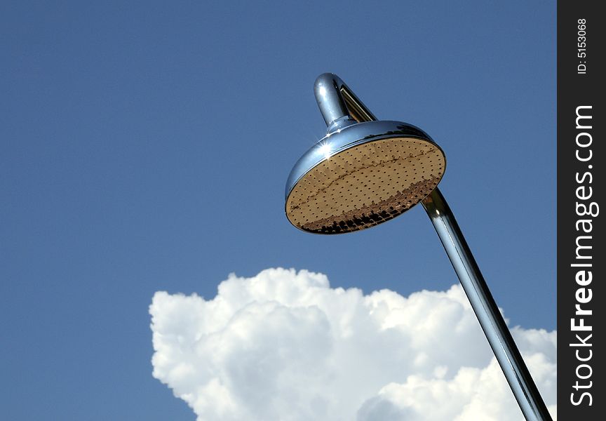 Chrome outdoor shower with cloud against blue sky. Chrome outdoor shower with cloud against blue sky