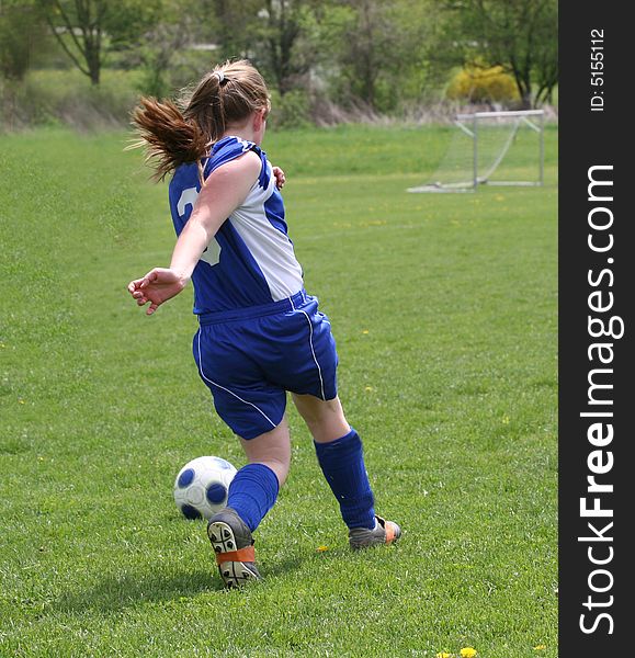 Teen Youth Girls chasing ball down soccer field. Teen Youth Girls chasing ball down soccer field.