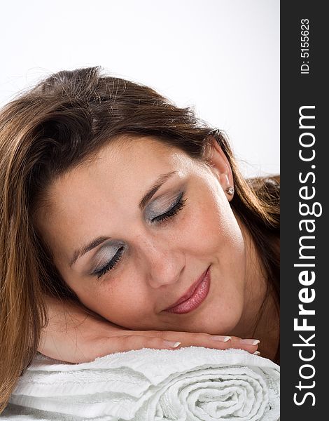 Attractive woman reposes on white towels with closed eyes. Attractive woman reposes on white towels with closed eyes.