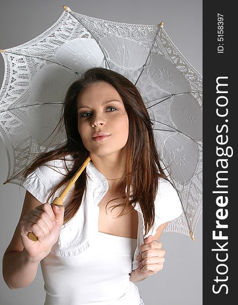 Young brunette girl with umbrella in white