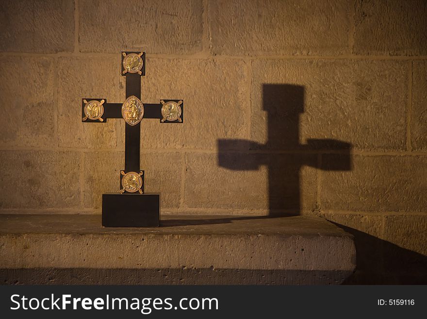 Cross and its shadow in a dark church