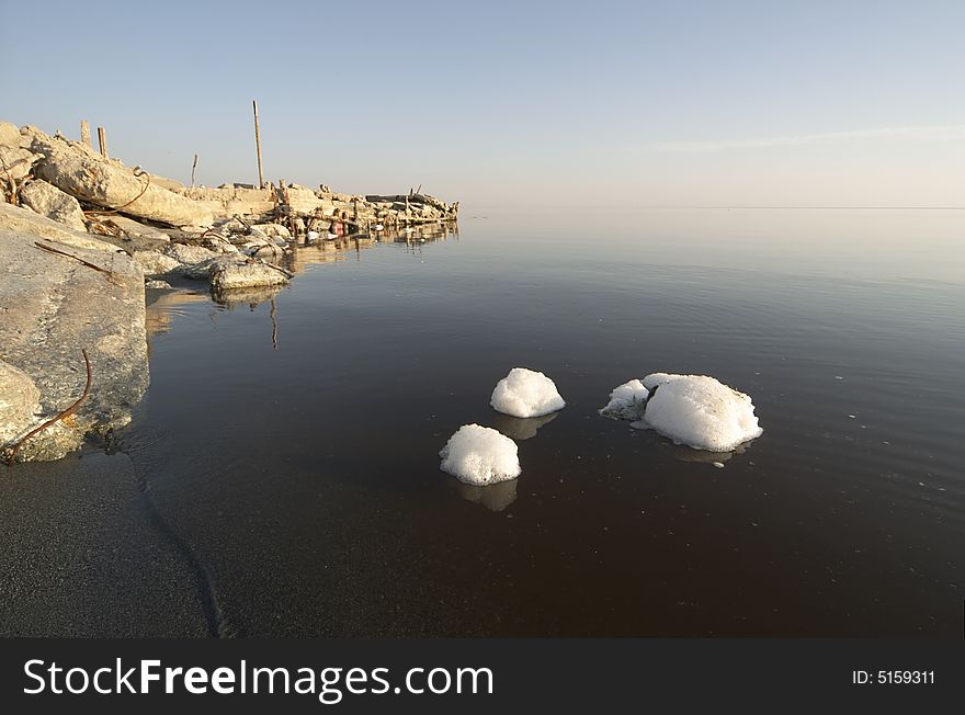 Chunks of white foam floating in the murky, polluted brine of the Salton Sea, California. Chunks of white foam floating in the murky, polluted brine of the Salton Sea, California.